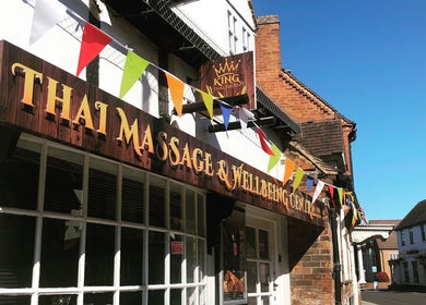Entrance of King Thai Therapy Knowle in Knowle, England, GB, decorated with colorful flags.
