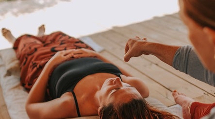 Person receiving relaxation therapy at Exhayl, Epsom, England, GB in a tranquil wooden floor setting.