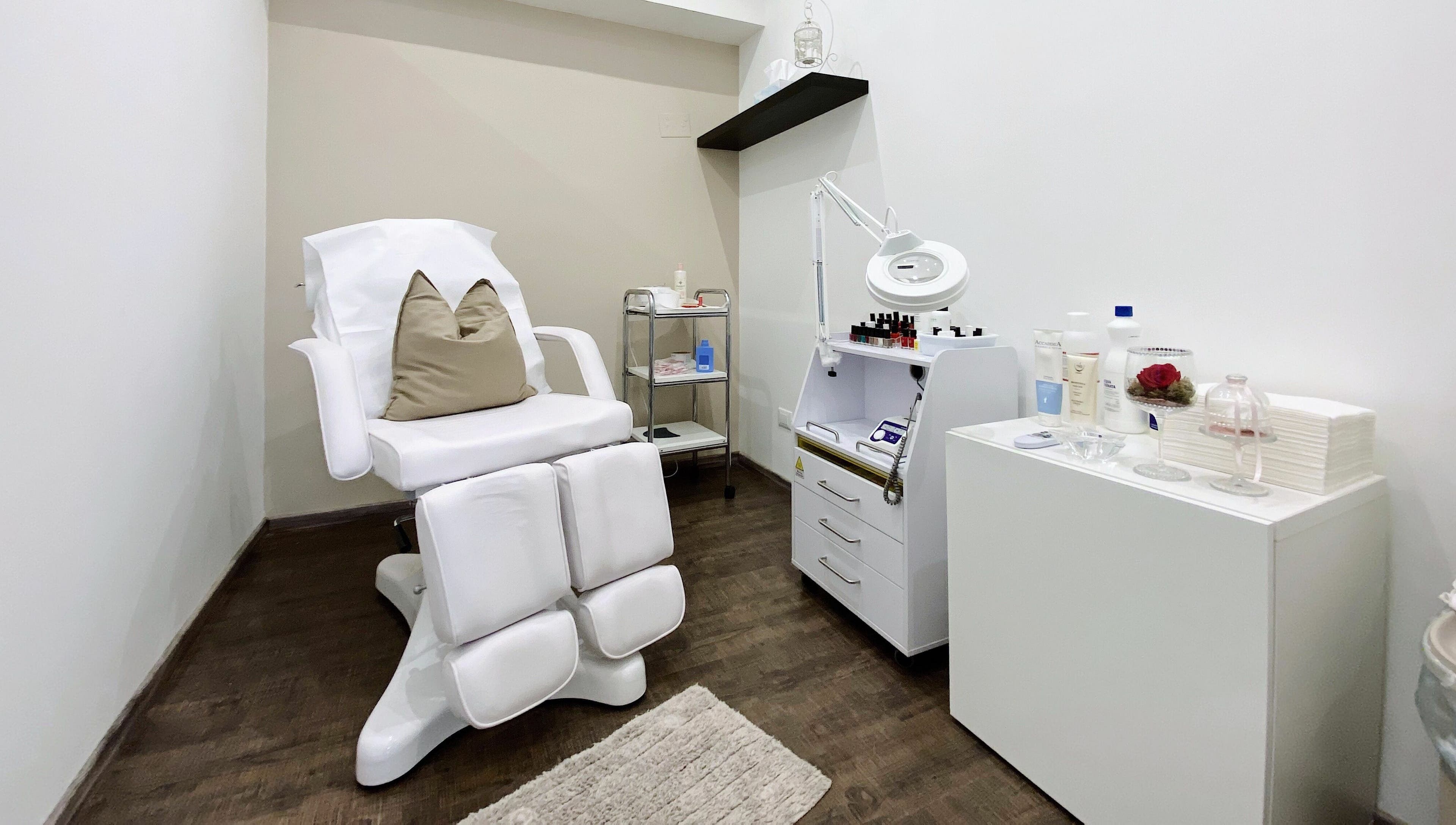 Sala trattamenti Bottega Estetica, Bracciano, Lazio, IT, con poltrona bianca e attrezzature moderne.