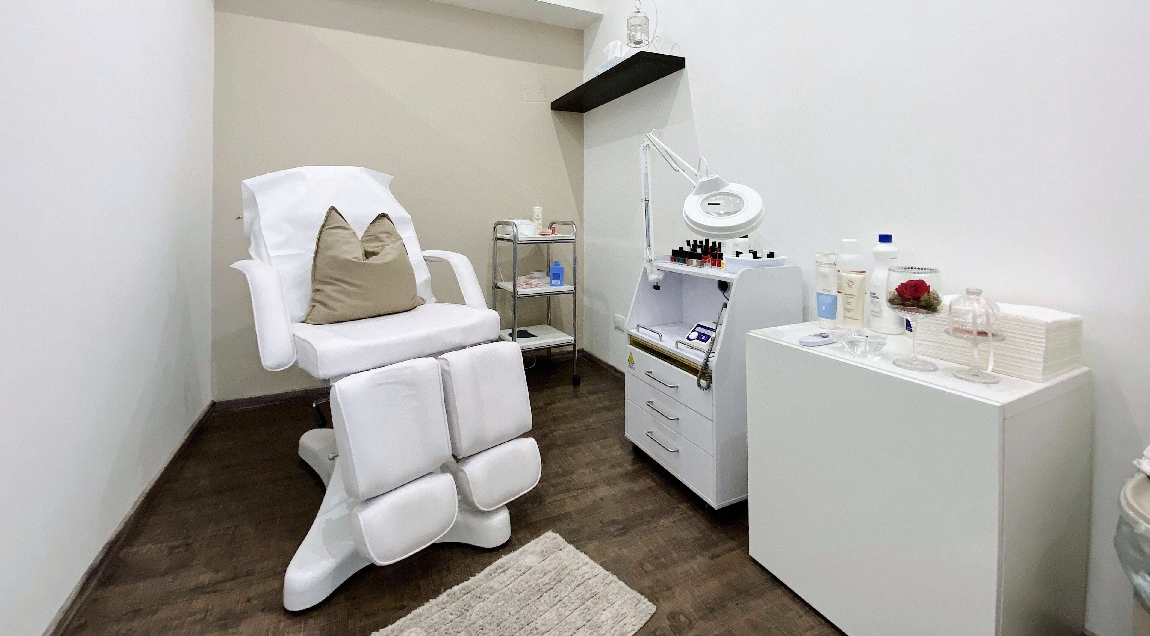 Sala trattamenti Bottega Estetica, Bracciano, Lazio, IT, con poltrona bianca e attrezzature moderne.