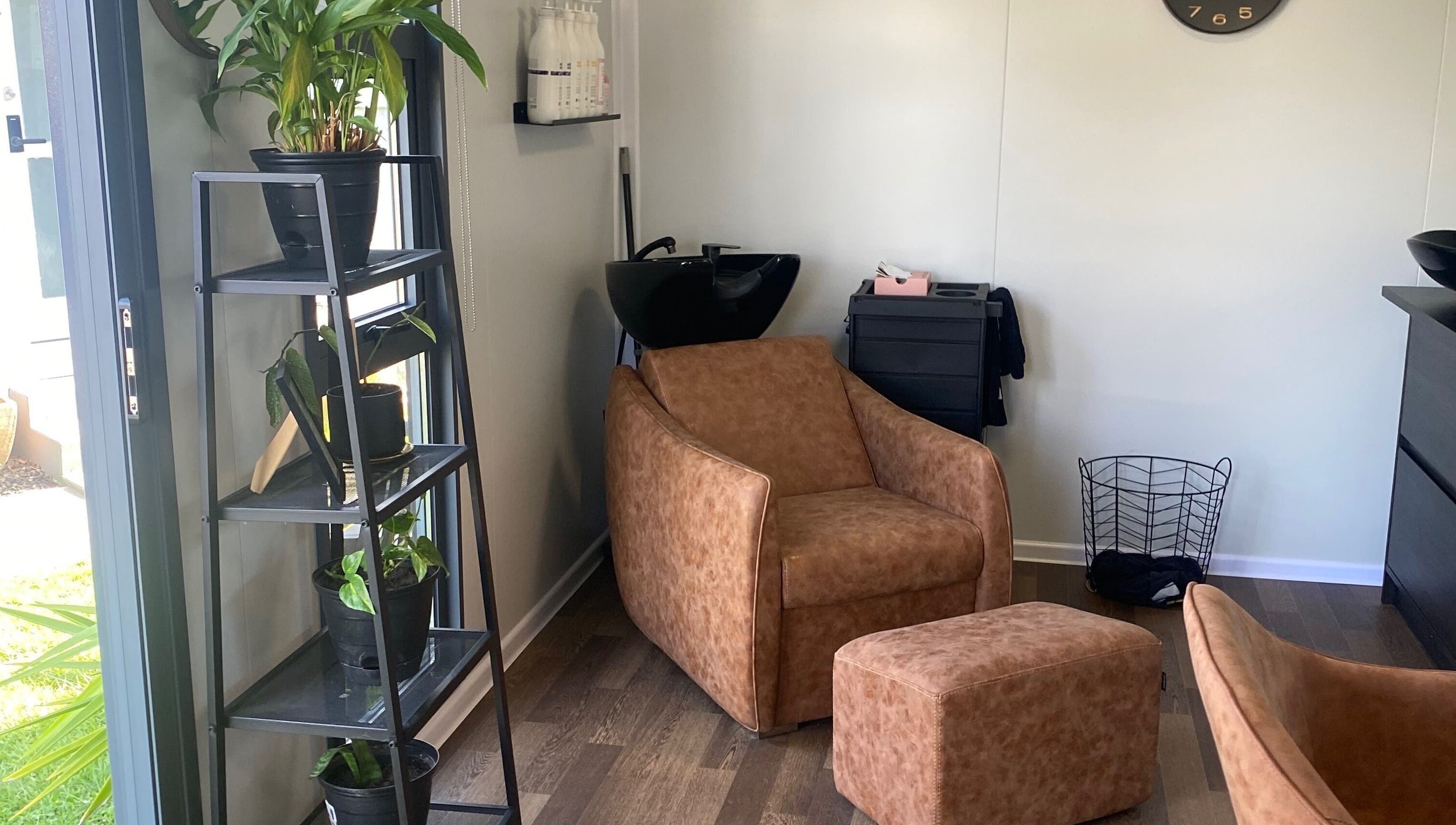 Relaxing corner at Colour Boutique, Christchurch, Canterbury Region, NZ with chair and plant decor.