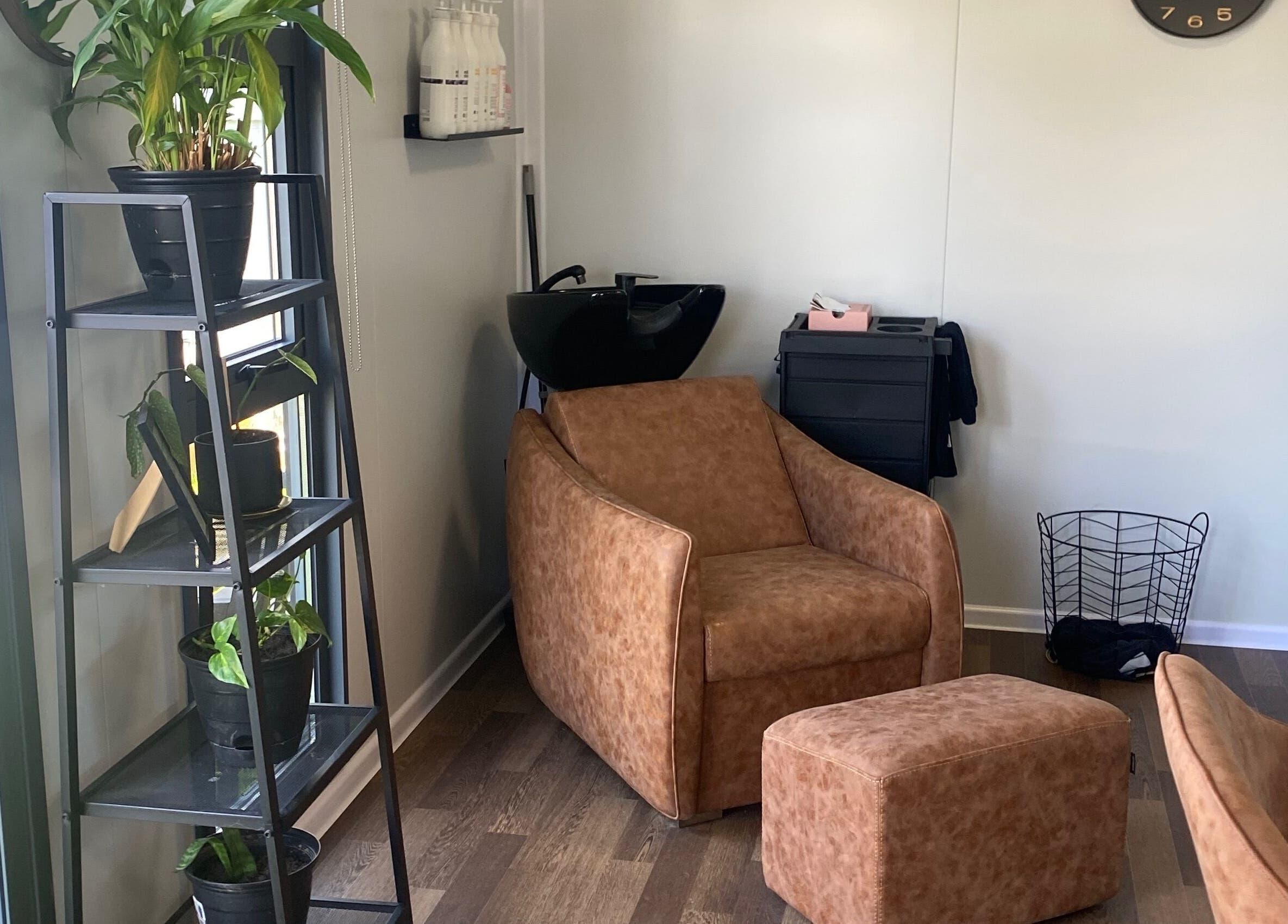 Relaxing corner at Colour Boutique, Christchurch, Canterbury Region, NZ with chair and plant decor.