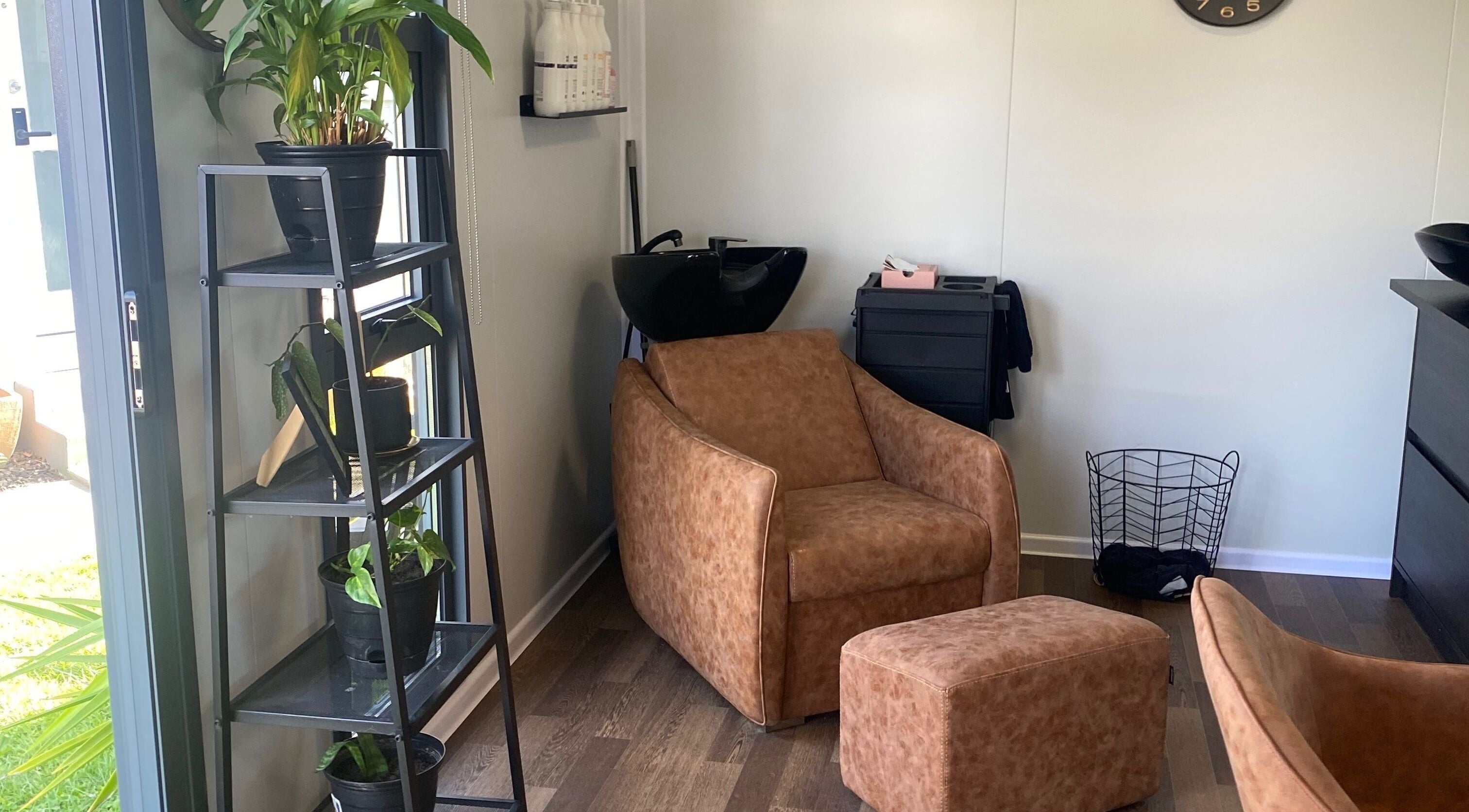 Relaxing corner at Colour Boutique, Christchurch, Canterbury Region, NZ with chair and plant decor.