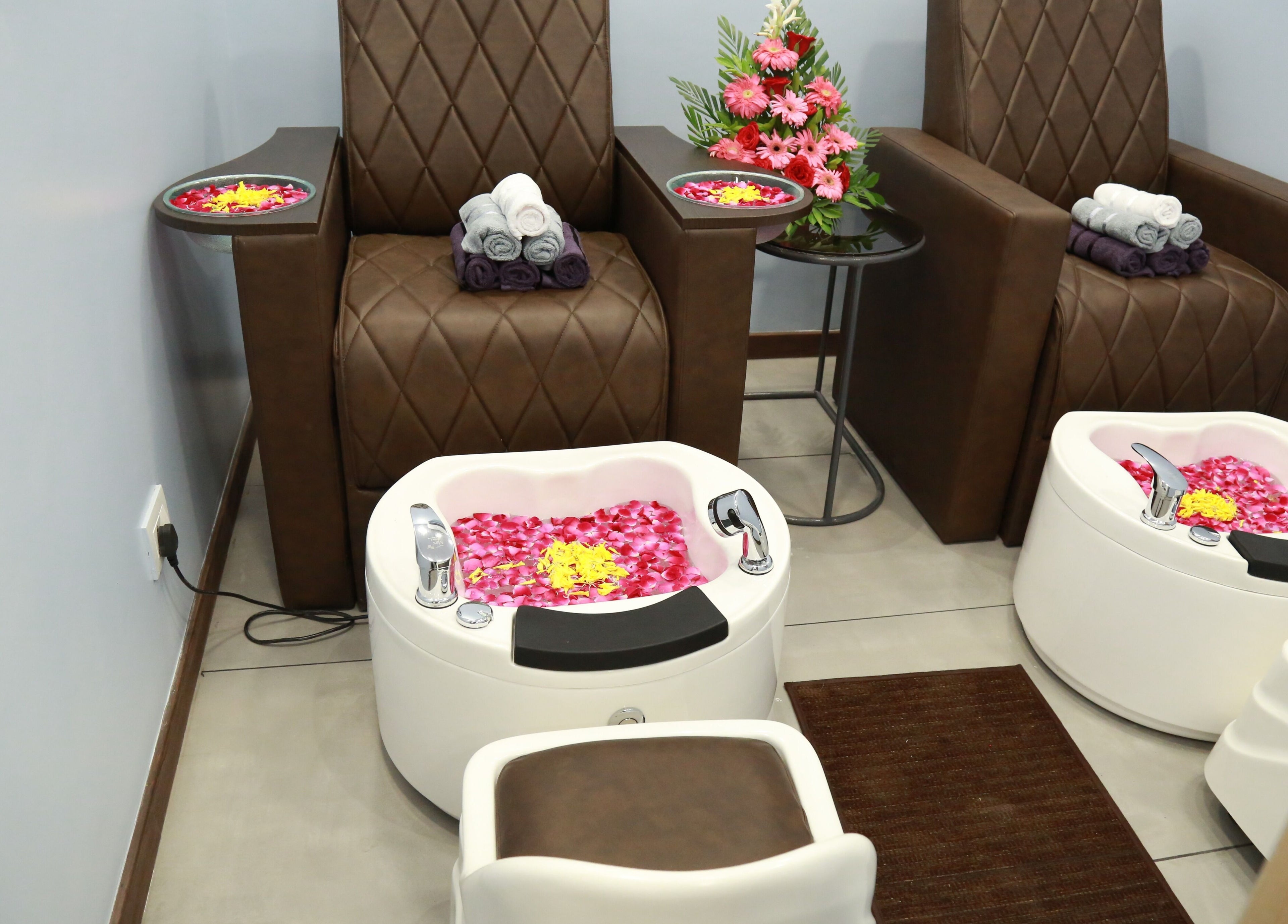 Luxurious pedicure setup at J and K Signature Unisex Salon, Anand, Gujarat, IN, featuring plush seating and floral decor.