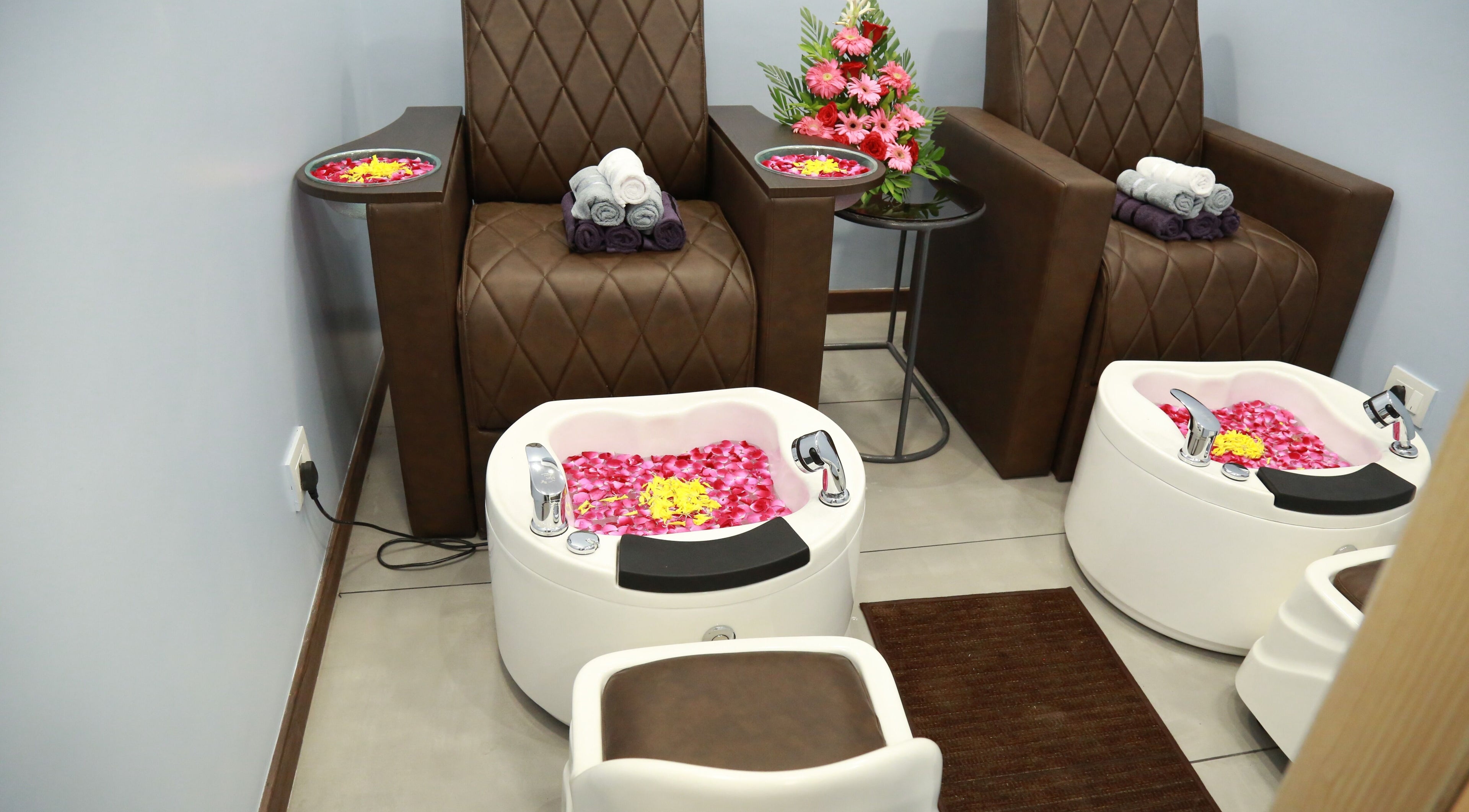 Luxurious pedicure setup at J and K Signature Unisex Salon, Anand, Gujarat, IN, featuring plush seating and floral decor.