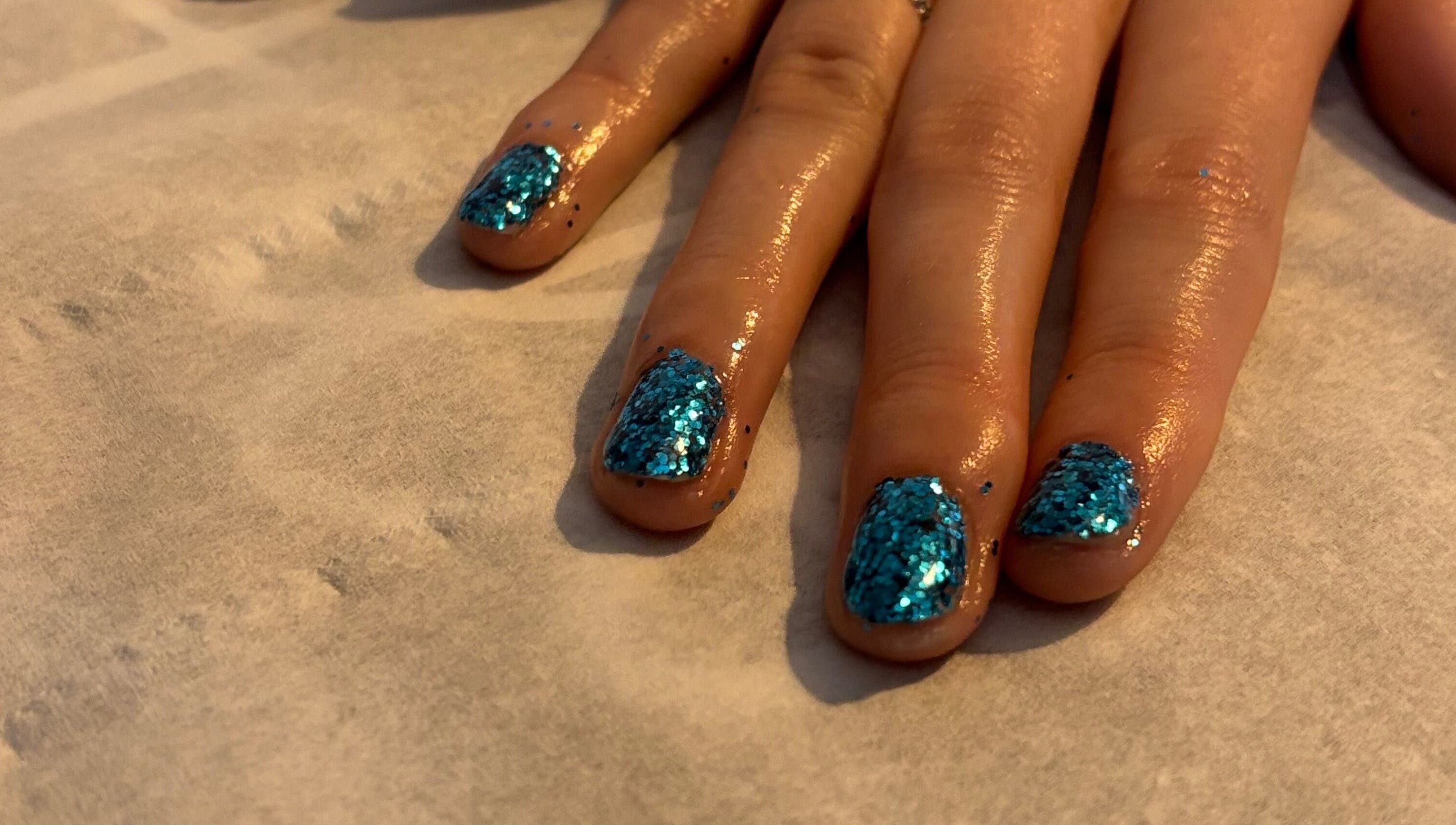 Close-up of glittery blue nails at Beauty and Beyond, Greenock, Scotland, GB.