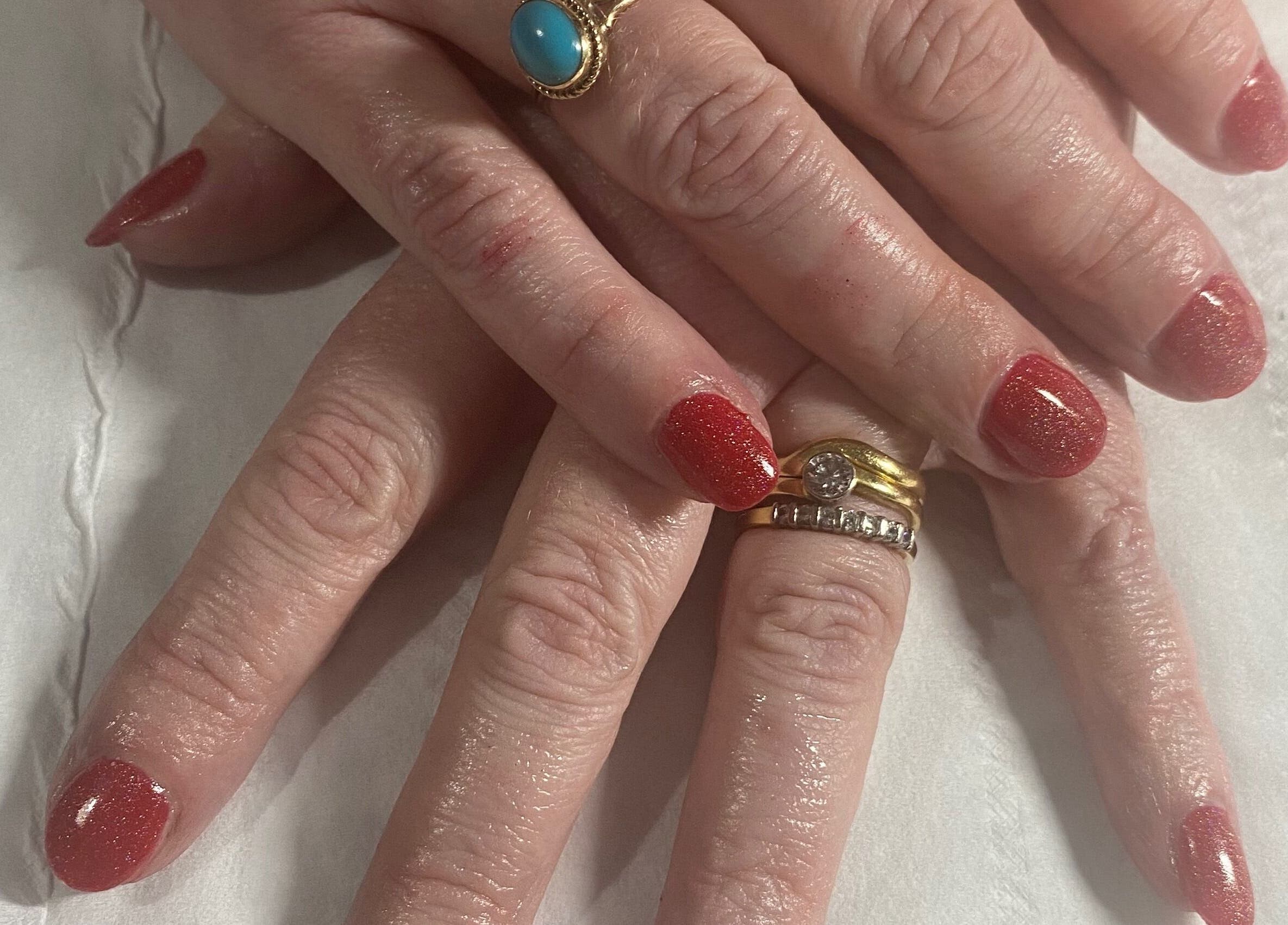 Elegant red manicured nails by Beauty and Beyond in Greenock, Scotland, GB, showcasing luxury and style.