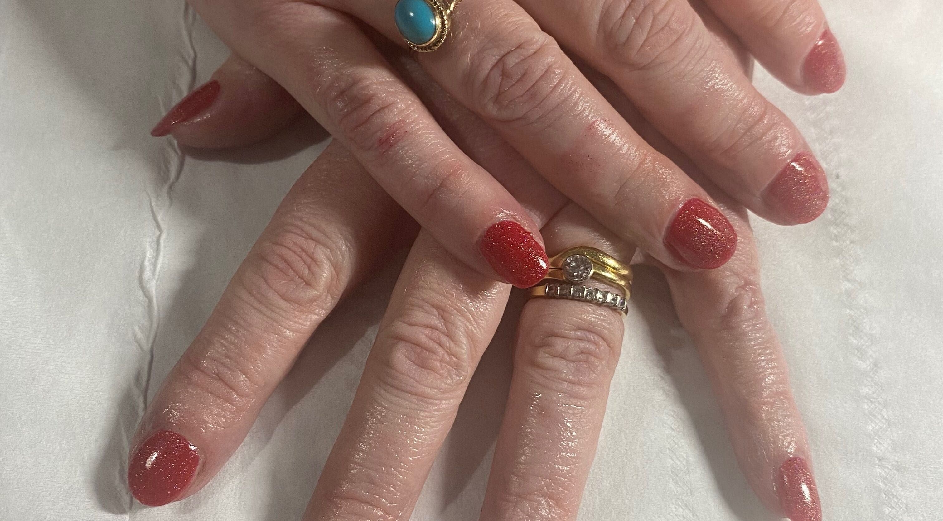 Elegant red manicured nails by Beauty and Beyond in Greenock, Scotland, GB, showcasing luxury and style.