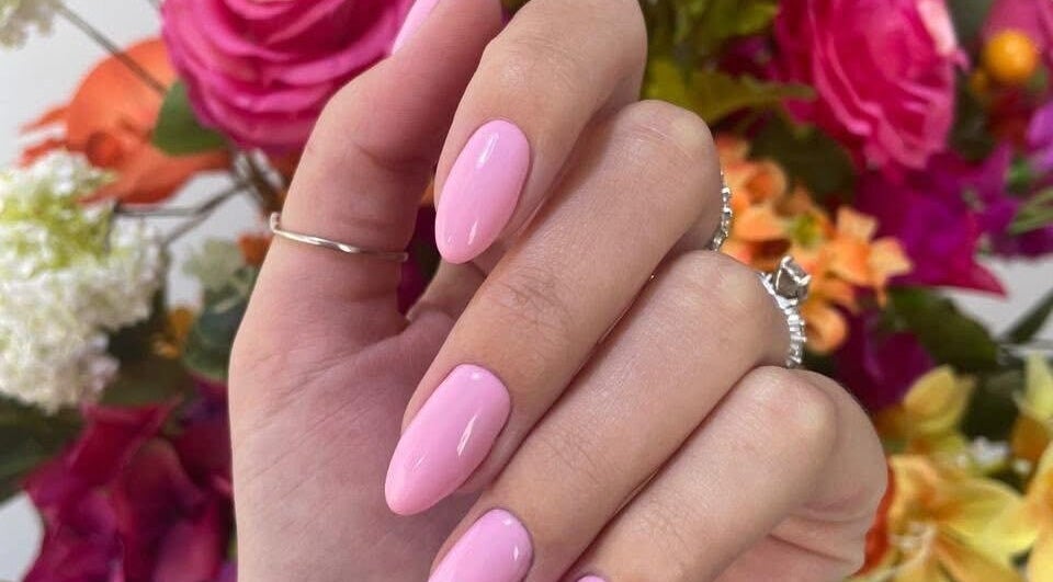 Elegant pink nail art at Skoonveldt, Klerksdorp, North West, ZA with vibrant floral background.