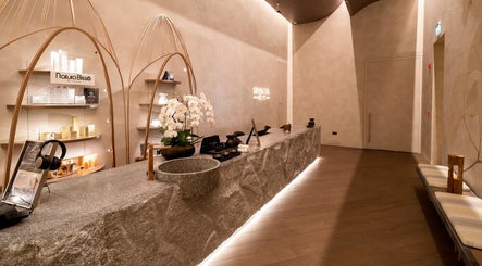 Elegant reception area of SENSASIA Stories in Dubai, Dubai, AE with a modern natural stone counter and decor.