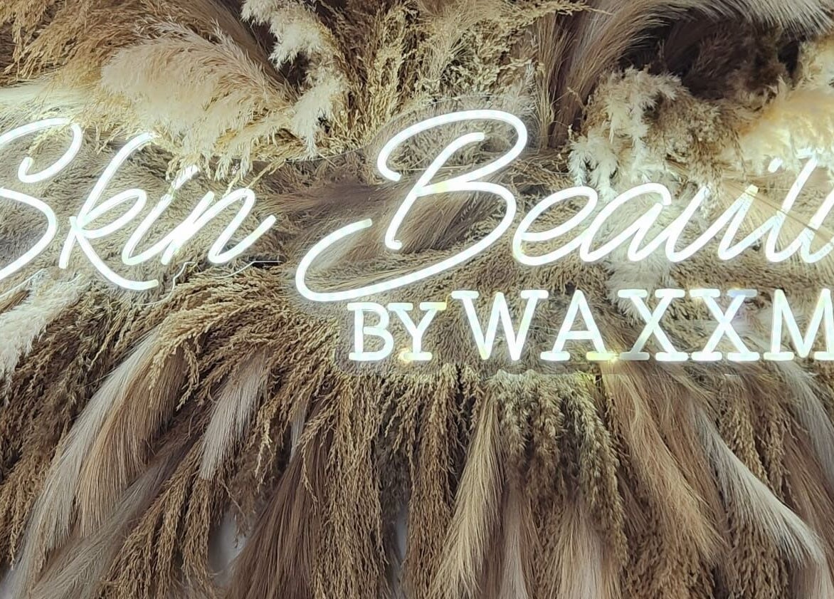 Illuminated Skin Beautii by Robinson Rd sign with pampas grass in Nassau, New Providence, BS.