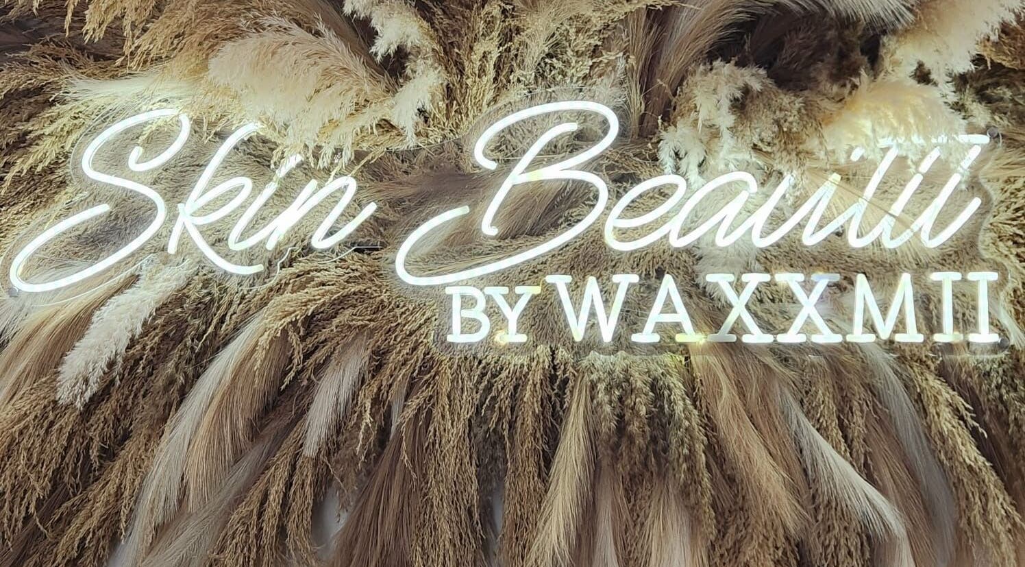 Illuminated Skin Beautii by Robinson Rd sign with pampas grass in Nassau, New Providence, BS.