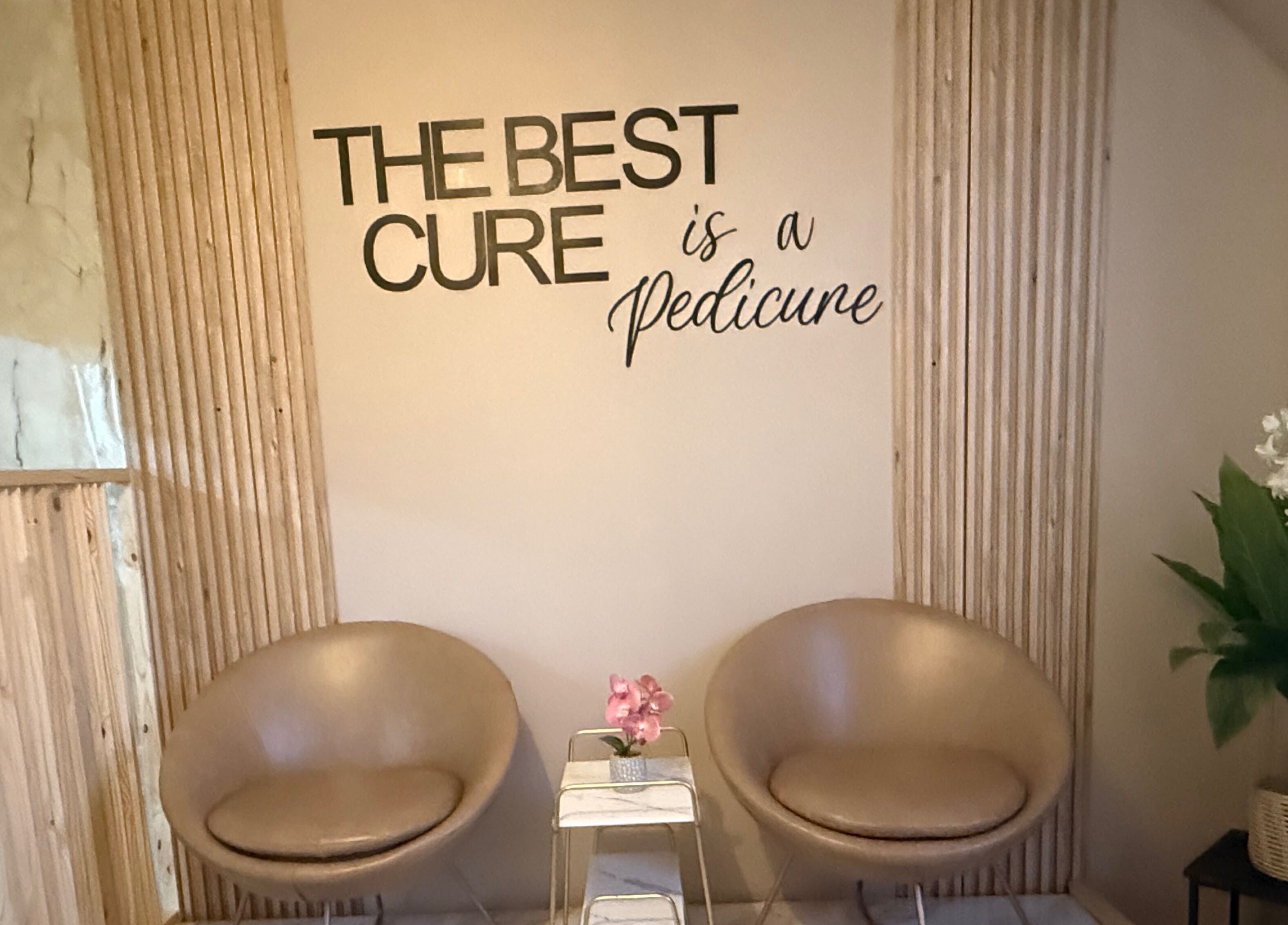 Cozy seating at Goddess Glow Pedi & Wax Bar, Cape Town, Western Cape, ZA with 'The Best Cure is a Pedicure' sign.