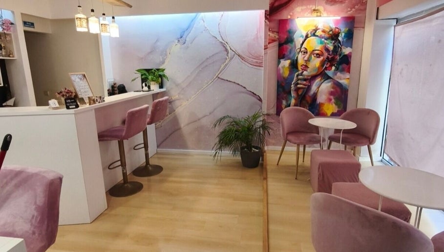 Interior elegante do Carl Areias Nail Bar em Póvoa de Varzim, Porto, PT, com decoração moderna e cadeiras rosa.