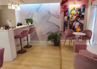 Interior elegante do Carl Areias Nail Bar em Póvoa de Varzim, Porto, PT, com decoração moderna e cadeiras rosa.