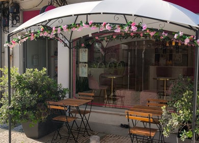 Entrada do Carl Areias Nail Bar em Póvoa de Varzim, Porto, PT com decoração floral e mesas externas.