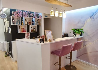 Recepção elegante do Carl Areias Nail Bar em Póvoa de Varzim, Porto, PT com decoração moderna e cadeiras rosas.