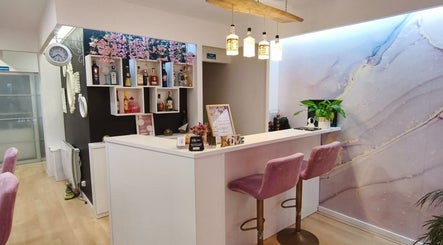Recepção elegante do Carl Areias Nail Bar em Póvoa de Varzim, Porto, PT com decoração moderna e cadeiras rosas.