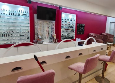 Interior do Carl Areias Nail Bar em Póvoa de Varzim, Porto, PT, destacando poltronas rosa e displays de esmaltes.
