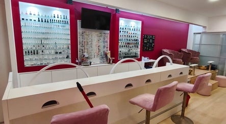 Interior do Carl Areias Nail Bar em Póvoa de Varzim, Porto, PT, destacando poltronas rosa e displays de esmaltes.