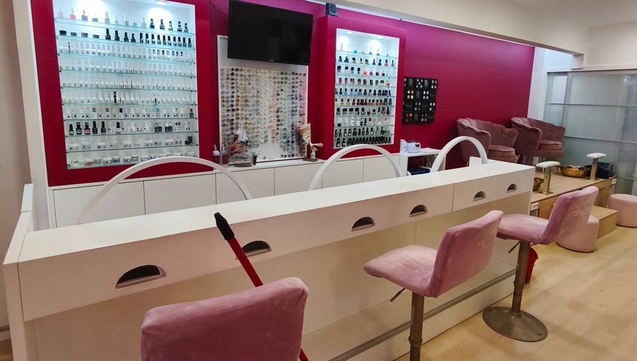 Interior elegante do Carl Areias Nail Bar em Póvoa de Varzim, Porto, PT, com poltronas e esmaltes variados.