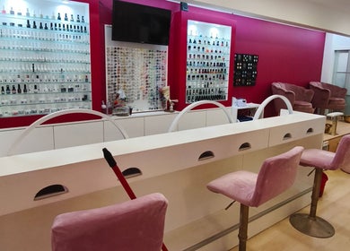 Interior elegante do Carl Areias Nail Bar em Póvoa de Varzim, Porto, PT, com poltronas e esmaltes variados.