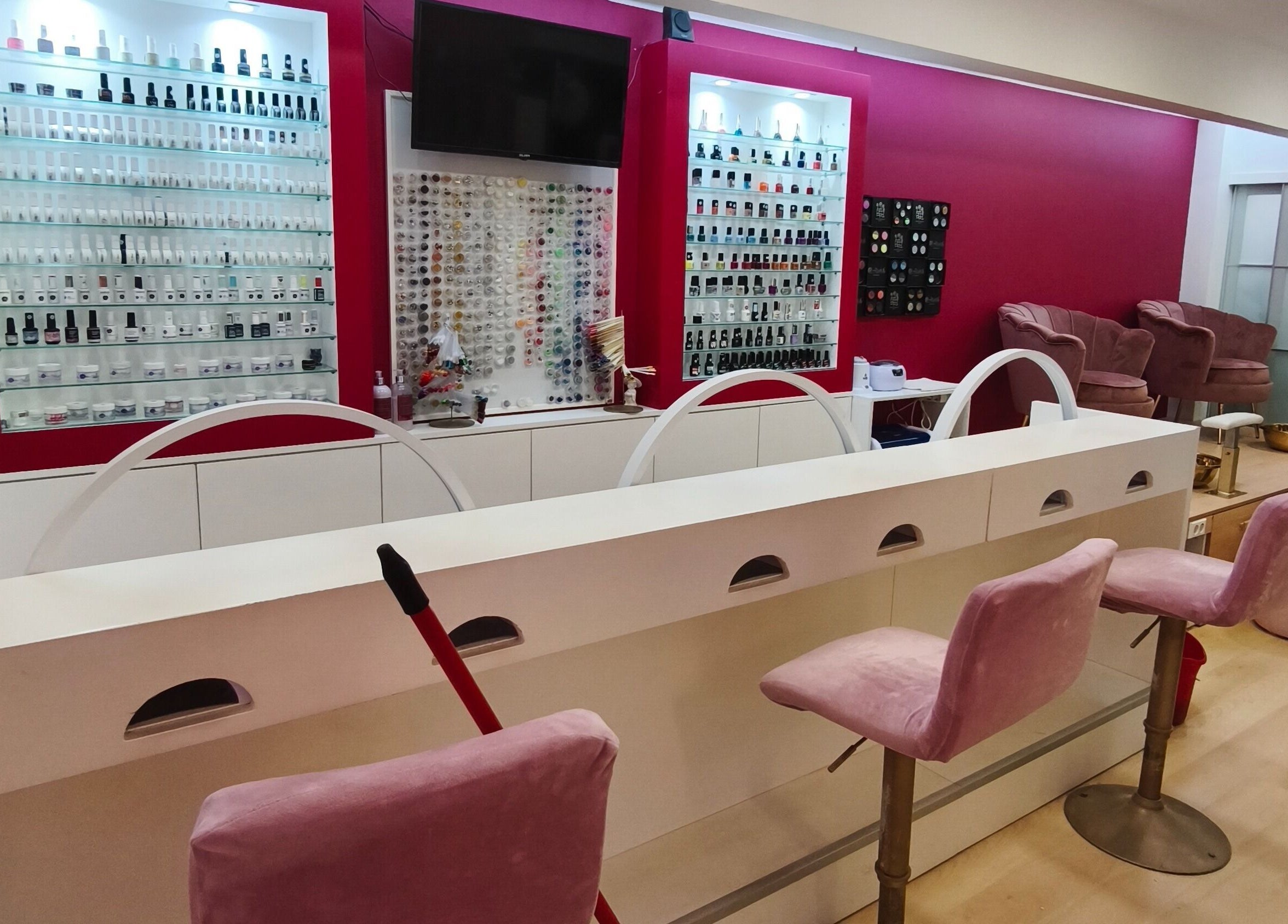 Interior elegante do Carl Areias Nail Bar em Póvoa de Varzim, Porto, PT, com poltronas e esmaltes variados.