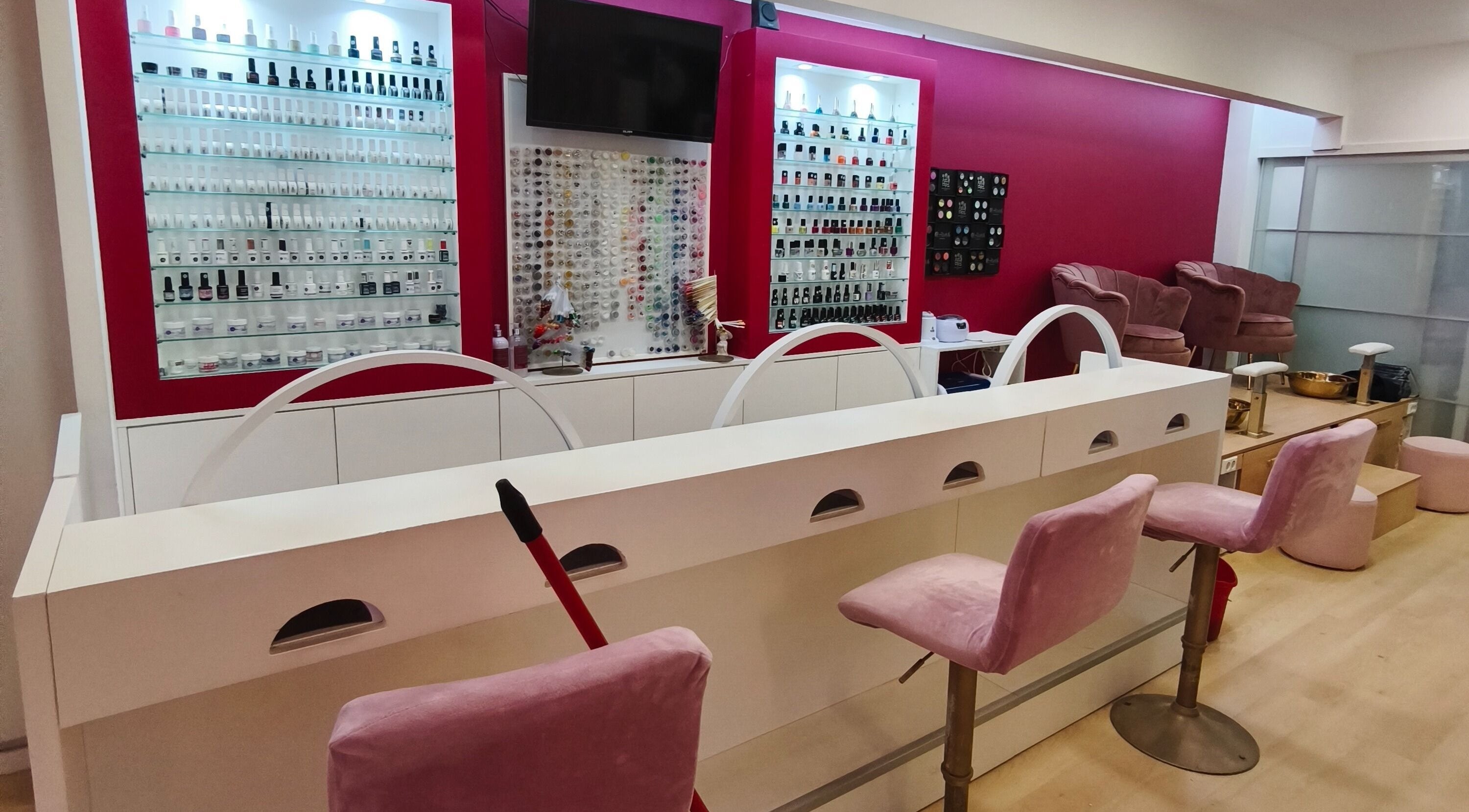 Interior elegante do Carl Areias Nail Bar em Póvoa de Varzim, Porto, PT, com poltronas e esmaltes variados.