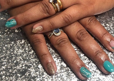 Elegant nail art at The Glam and Glow Studio in Havant, England, GB, showcasing sparkling turquoise and gold design.