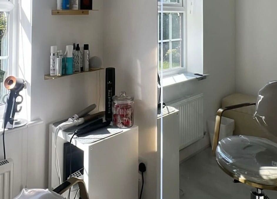 Modern salon interior at Doll Hair By Lara, Leicester, England, GB, featuring styling chair and hair products.