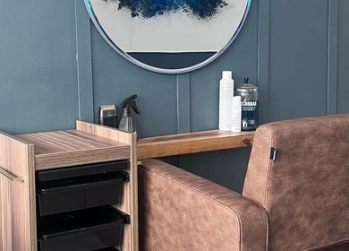 Elegant salon chair and vanity at Nv Studio, Exeter, England, GB, showcasing modern beauty equipment.