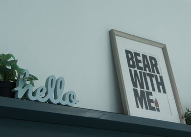 Stylish wall decor with 'Bear With Me' and 'hello' sign at Nv Studio, Exeter, England, GB.