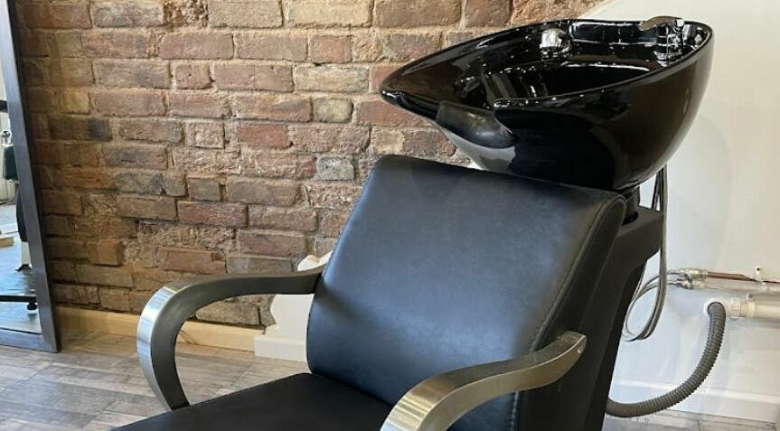 Modern hair wash station at Freestyle - Long Crendon, Long Crendon, England, GB, with brick wall backdrop.