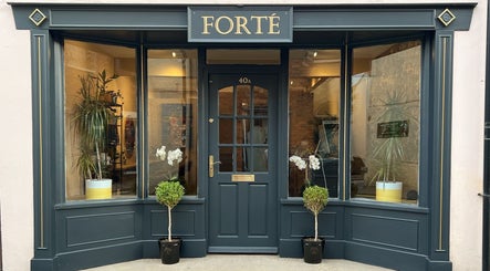 Elegant façade of Forté, a beauty venue in Louth, England, GB with plants and glass windows.