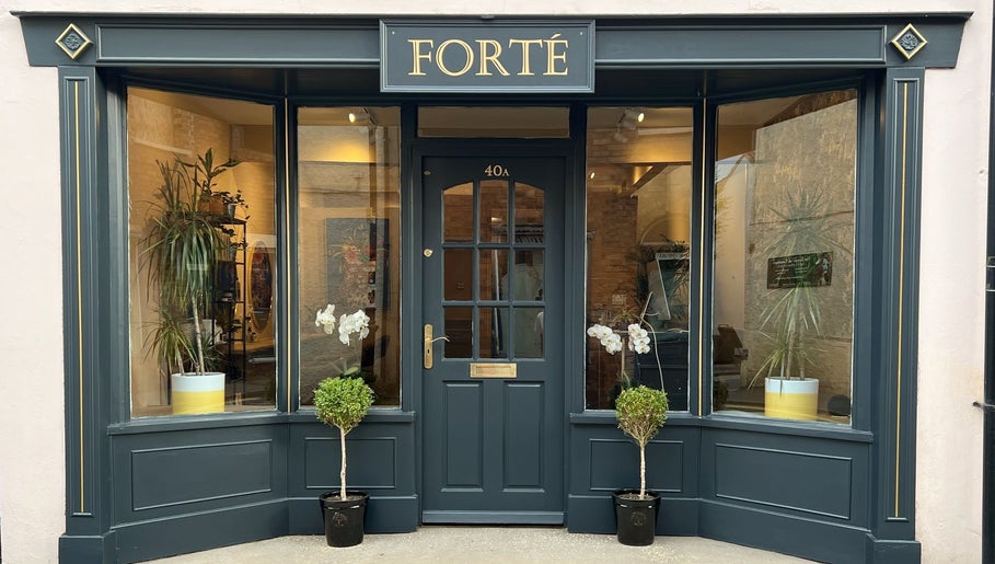 Front entrance of Forté in Louth, England, GB, showcasing sleek design and lush plants.