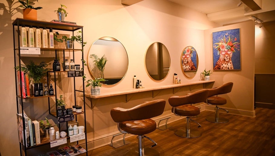 Stylish salon seating with mirrors at Forté, Louth, England, GB. Chic decor and modern hair products are displayed.
