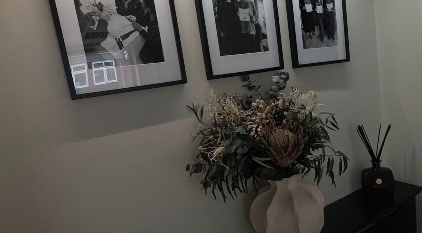 Elegant floral arrangement beneath framed photos at Lux Beauty in Cannock, England, GB.