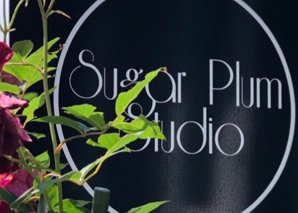 Sugar Plum Studio sign in Hamilton, Waikato, NZ with vibrant flowers and green leaves.