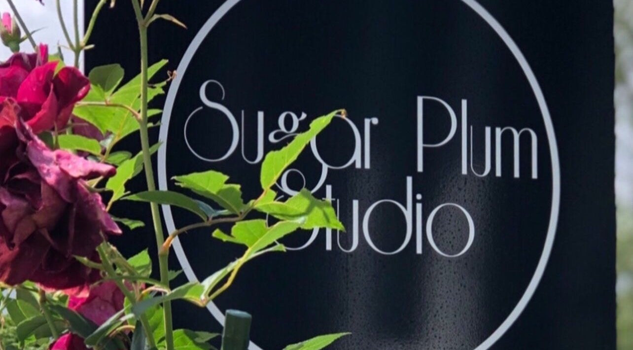 Sugar Plum Studio sign in Hamilton, Waikato, NZ with vibrant flowers and green leaves.