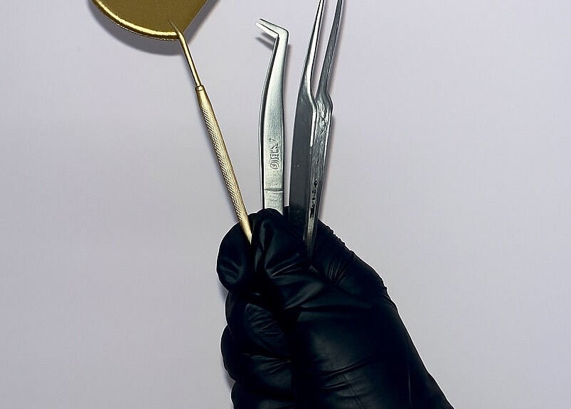 Professional beauty tools in gloved hand at PA Beauty, Highworth, England, GB.