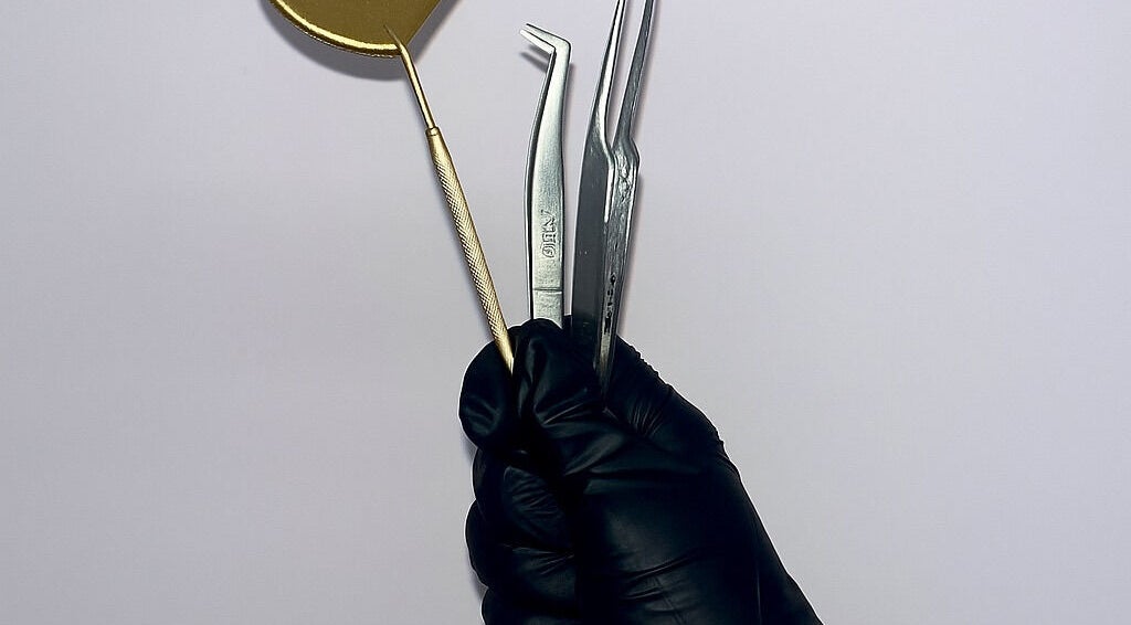 Professional beauty tools in gloved hand at PA Beauty, Highworth, England, GB.