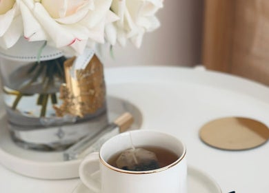 Elegant tea setting at Fountain of Youth, Ħal Balzan, MT, with roses and a golden-rimmed cup.