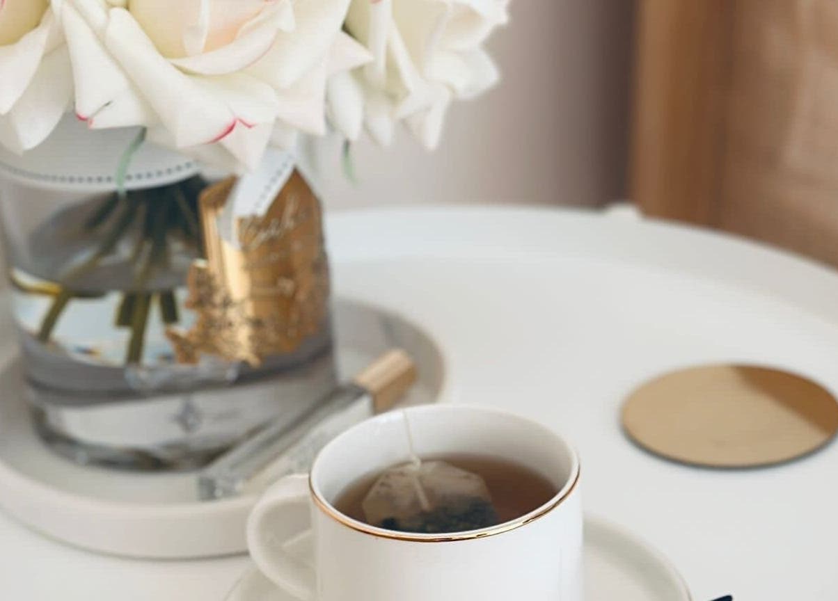 Elegant tea setting at Fountain of Youth, Ħal Balzan, MT, with roses and a golden-rimmed cup.