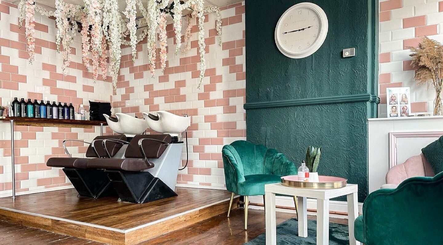 Stylish interior at MK Salon, Lowestoft, England with floral decor and green chairs near washing stations.