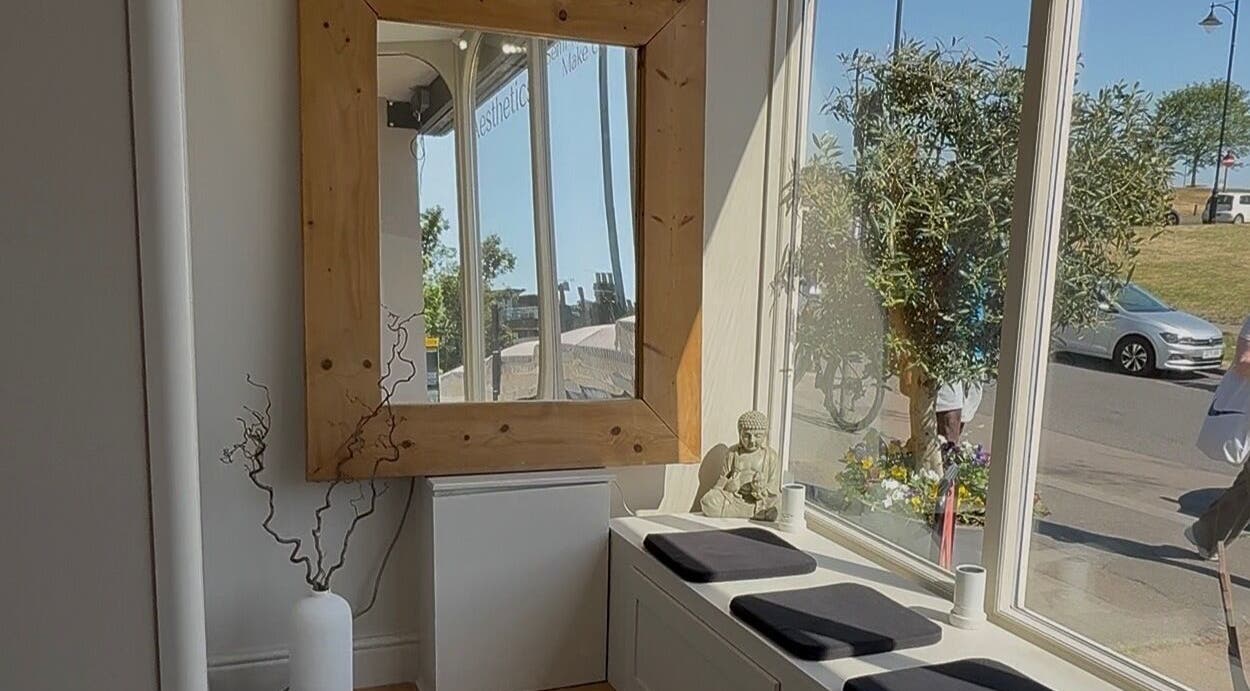 Inviting seating area with large mirror at Quinns Tanning and Aesthetics, London, England, GB.