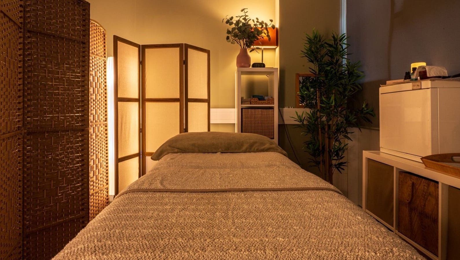 Tranquil therapy room at Heal Studio, London, England GB, featuring a cozy bed and ambient lighting.