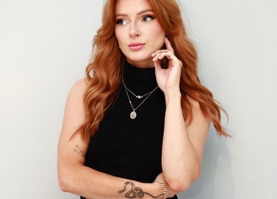 Stylish woman with red hair at Rachel Crowe Makeup, Dundee, Scotland, GB, showcasing elegant jewelry.