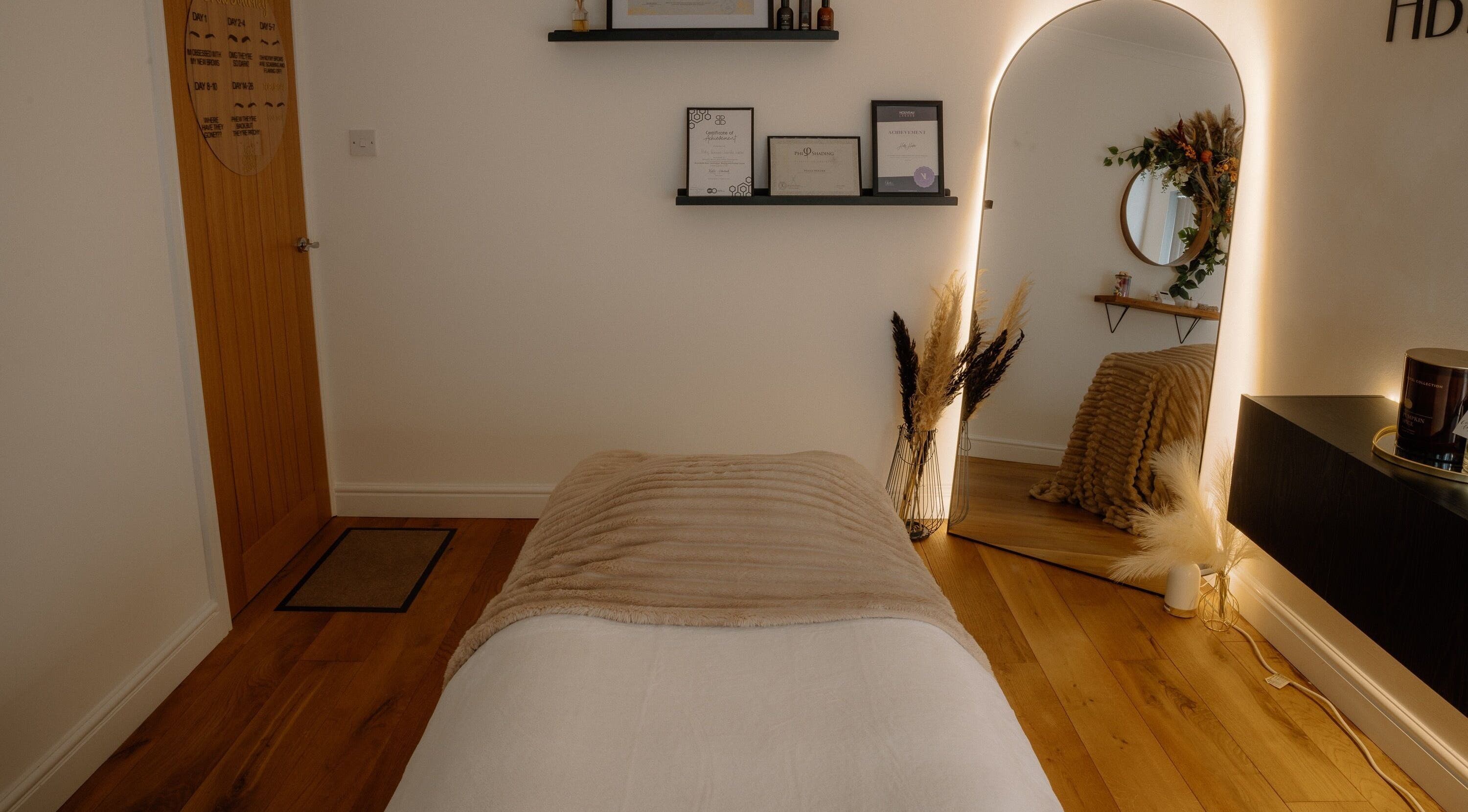 H Brows & Beauty serene treatment room in Lightwater, England, GB with ambient lighting and decor.