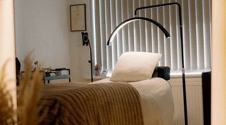 Relaxing treatment room at H Brows & Beauty in Lightwater, England, GB, featuring a cozy massage bed and soft lighting.