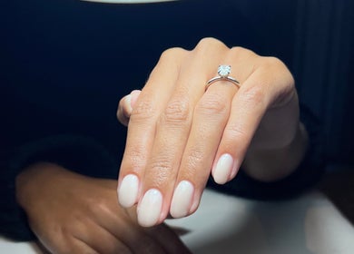 Close-up of manicured hand at Beau.t in Horsham, England, GB showcasing soft pink nails and ring.